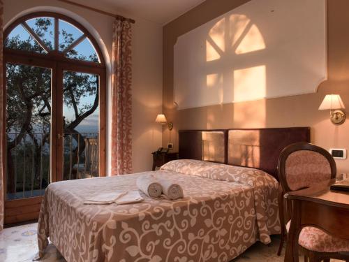 sypialnia z łóżkiem i dużym oknem w obiekcie Villa Giovanna w Sorrento