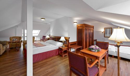 マリアーンスケー・ラーズニェにあるホテル コンチネンタルのベッドとテーブルが備わるホテルルームです。