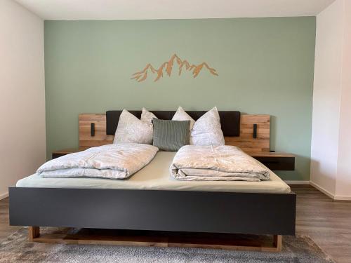 a bedroom with a bed with a wooden head board at Appartement Two in Ötztal-Bahnhof