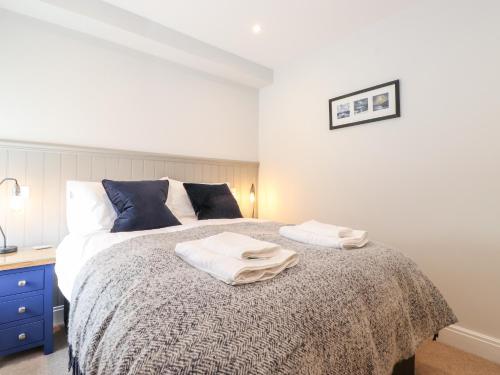 1 dormitorio con 1 cama con 2 toallas en Adas Hideaway, en Kendal