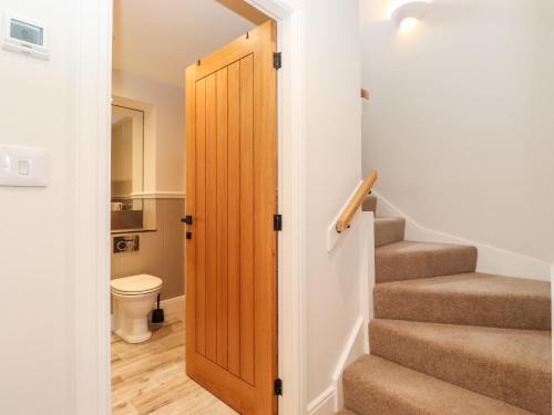 Una escalera con una puerta de madera en una casa en Adas Hideaway, en Kendal