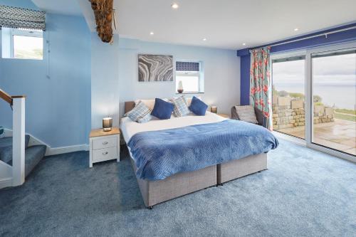 een slaapkamer met een groot bed met blauwe muren bij Host & Stay - Fairview House in Ravenscar