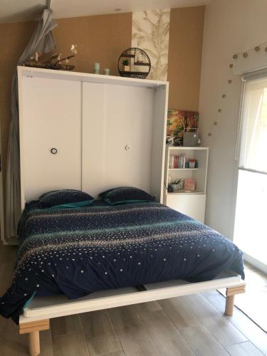 1 dormitorio con 1 cama grande y cabecero blanco en Au Petit C'Alain en Toulouse