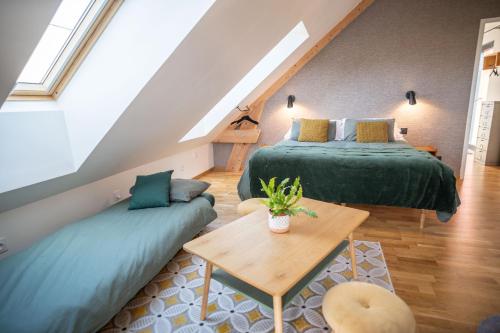 a attic room with two beds and a table at Le jardin des 4 saisons in Le Mans