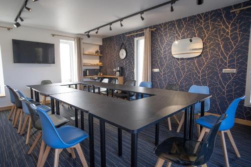 a conference room with a long table and chairs at Le jardin des 4 saisons in Le Mans