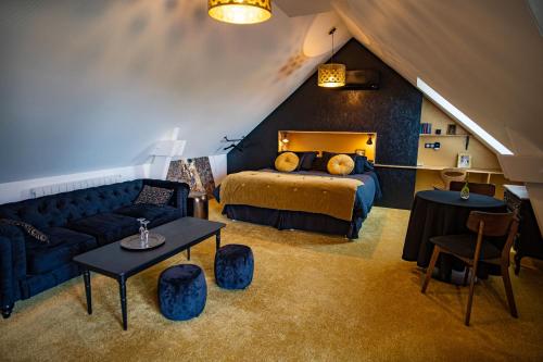 a bedroom with a bed and a couch in a attic at Le jardin des 4 saisons in Le Mans