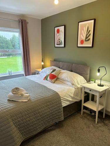 a bedroom with a bed and a table and a window at Homely house, foot of Snowdonia with private parking in Llanberis