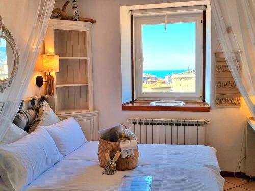 - une chambre avec un lit et une fenêtre donnant sur l'océan dans l'établissement Le Petit Phare, à Trieste