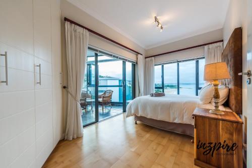 a bedroom with a bed and a view of the ocean at Gouriqua 401 in Mossel Bay