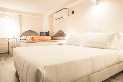a white bedroom with a large white bed at Brera Apartments in San Marco in Milan