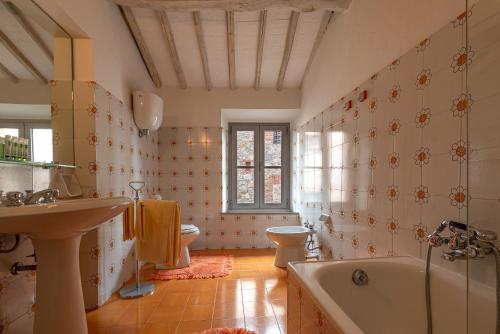 a bathroom with a tub and a toilet and a sink at La Foresteria di Castell'in Villa in Castelnuovo Berardenga