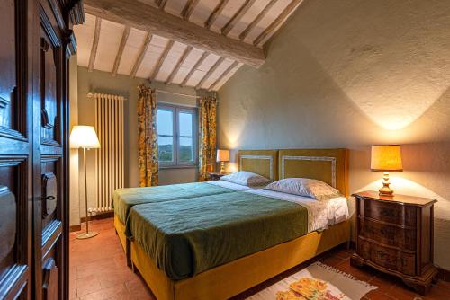 Un dormitorio con una cama grande y una ventana en La Foresteria di Castell'in Villa, en Castelnuovo Berardenga