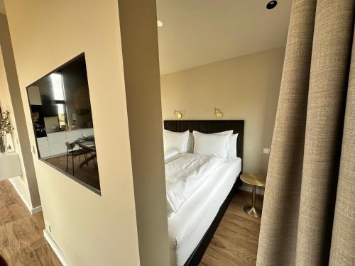 a bedroom with a large white bed with a mirror at Urriðafoss Waterfall Lodges in Selfoss