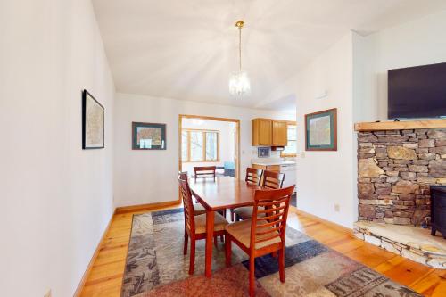 a dining room with a table and chairs and a fireplace at Raven's Respite in Saluda