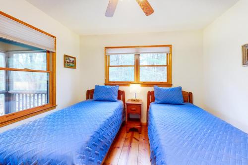two beds in a bedroom with blue comforter at Raven's Respite in Saluda