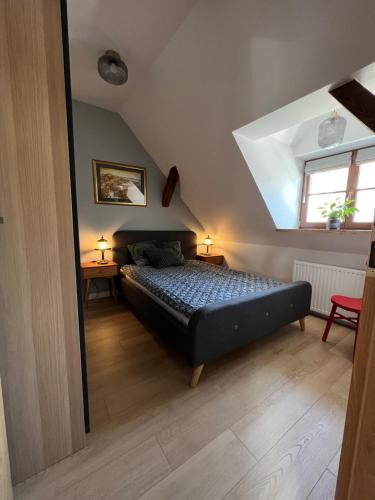 a bedroom with a bed and two tables and a window at Apartament Miasteczko in Kazimierz Dolny