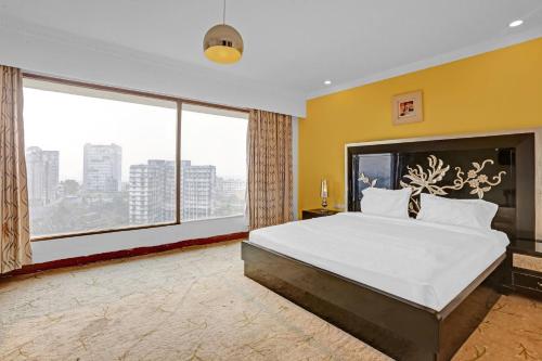 1 dormitorio con 1 cama grande y ventana grande en Townhouse Royal Palms Shared Serviced Apartment, en Bombay
