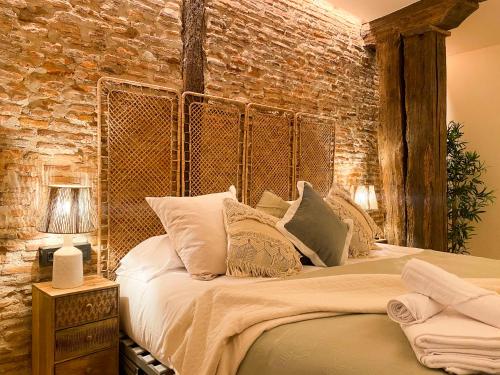 una camera con un grande letto con un muro di mattoni di Ribera AC by Staynnapartments a Bilbao