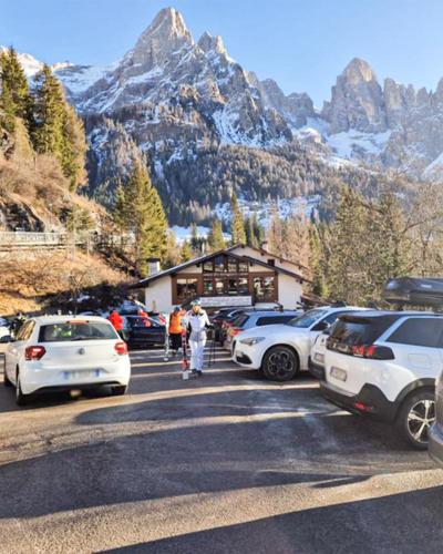 a parking lot with cars parked in front of a mountain at Scoiattolo Apartment in San Martino di Castrozza