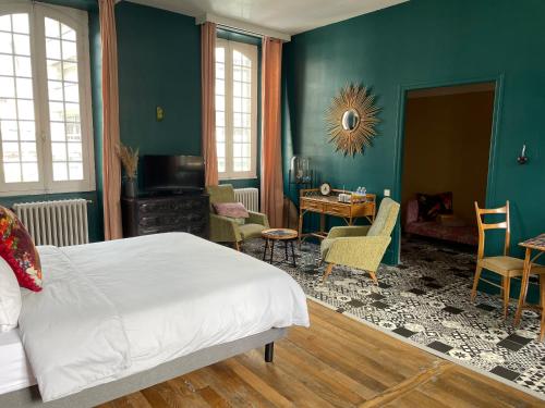 una camera con letto, tavolo e sedie di La Maison aux murs anciens et ses chambres a Tarbes