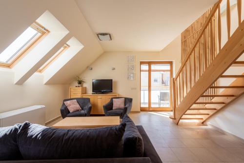 ein Wohnzimmer mit einem Sofa und 2 Stühlen in der Unterkunft Apartamenty Sun Seasons 24 - Bałtyckie in Rewal