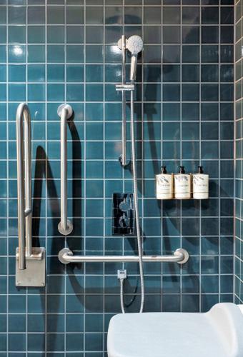 a blue tiled bathroom with a shower and a toilet at Mollie's Motel & Diner Bristol in Bristol