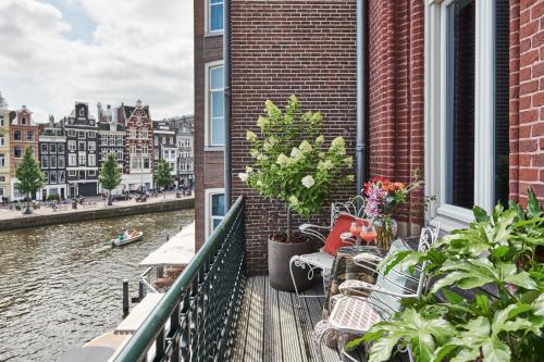 a balcony of a building with plants and a river at De L’Europe Amsterdam – The Leading Hotels of the World in Amsterdam