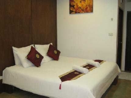 una cama blanca con almohadas en una habitación en Lamai Perfect Resort, en Lamai