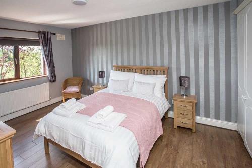 a bedroom with a large bed with two towels on it at Sleepy Rock in Dungarvan