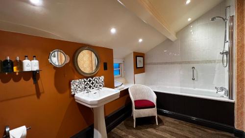 a bathroom with a sink and a bath tub at The Red Lion Inn in Long Compton