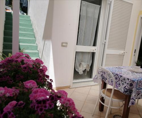 una stanza con tavolo e fiori e finestra di Casa La Posidonia a Ischia
