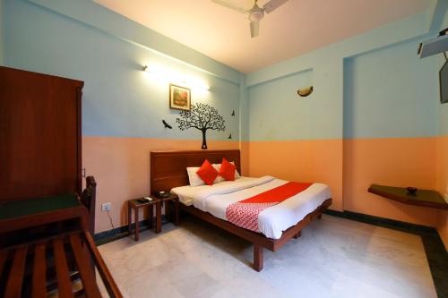a bedroom with a bed with orange and blue walls at Collection O Hotel Blue Bird in Jaipur