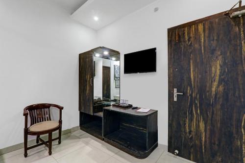 Habitación con escritorio, silla y espejo. en Capital O Affection Inn, en Chinhat