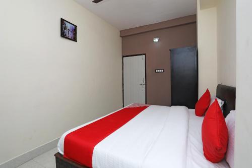 a bedroom with a large bed with red pillows at Hotel O Regal Stays in Chandaka