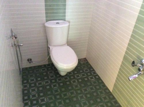 a small bathroom with a toilet in a stall at Anna Homestay in Munnar