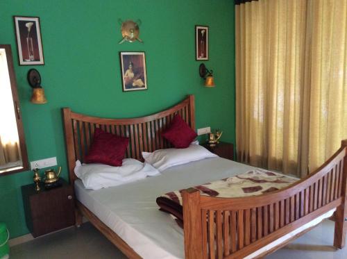 a bedroom with a bed with a green wall at Anna Homestay in Munnar