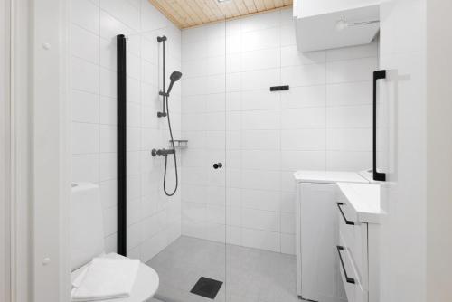 a white bathroom with a shower and a toilet at Forenom Serviced Apartments Espoo Saunalahti in Espoo