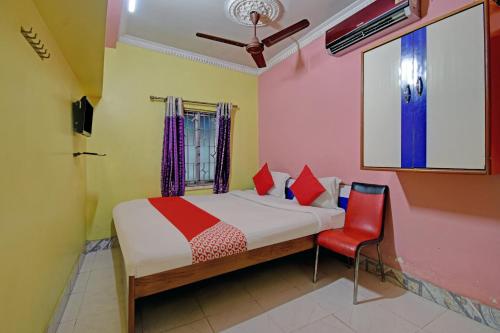 um quarto com uma cama e uma cadeira vermelha em Flagship Continental Stays Near Netaji Subhash Chandra Bose International Airport em Gauripur