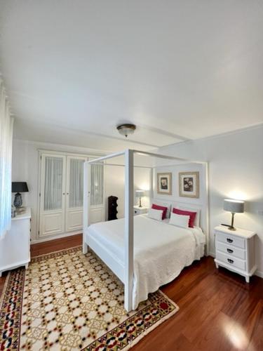 um quarto com uma cama branca e almofadas vermelhas em Cocas House - Alcobaça em Alcobaça