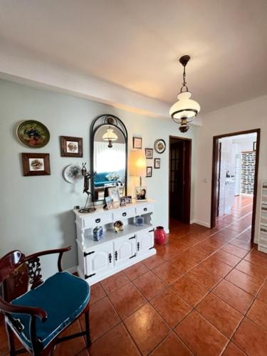 uma sala de estar com uma cadeira e um espelho em Cocas House - Alcobaça em Alcobaça