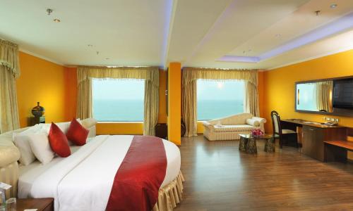 a hotel room with a large bed and a desk at The Quilon Beach Hotel and Convention Center in Kollam