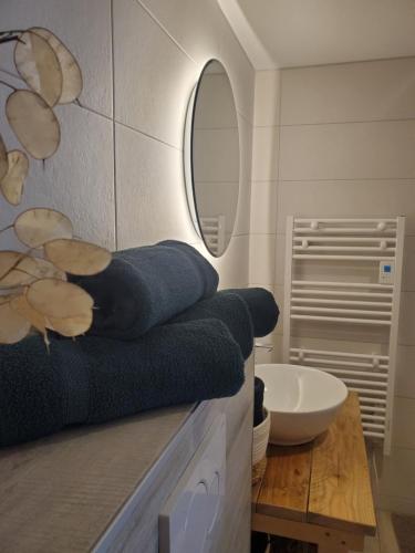 La salle de bains est pourvue d'un lavabo, d'un miroir et de serviettes. dans l'établissement Cale 32 - Chambres d'hôtes, à Saint-Jean-de-Monts