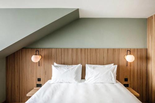 a bedroom with a bed with two pillows and two lights at Mollie's Motel & Diner Oxfordshire in Faringdon