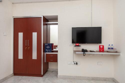 a room with a door and a tv on a wall at Super Hotel O Le Mint OMR in Chennai