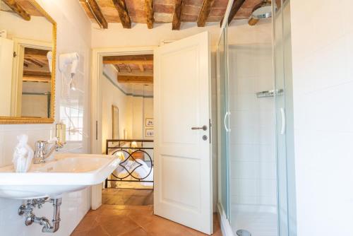 een badkamer met een wastafel en een douche bij Palazzo Mosela Alla Porta in Montepulciano