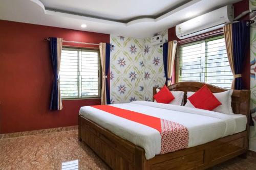um quarto com uma cama com paredes vermelhas e janelas em OYO Flagship 76044 Layeeree Resort em Bālianta
