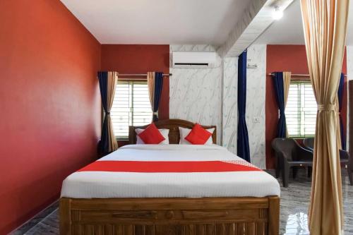 um quarto com uma cama grande e paredes vermelhas em OYO Flagship 76044 Layeeree Resort em Bālianta