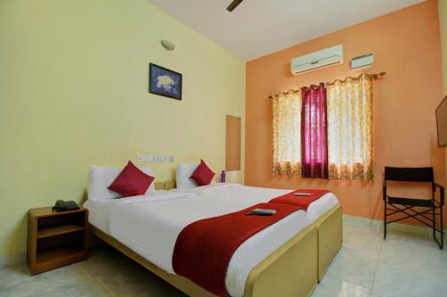 una camera con un grande letto e una sedia di Infosys Thoraipakkam Near Ecr Beach a Chennai