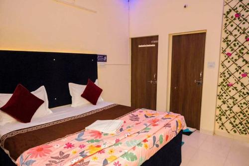 BhilaiにあるPOP Hotel Blue Starのベッドルーム1室(大型ベッド1台、カラフルな掛け布団付)