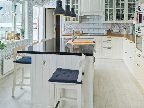 a kitchen with white cabinets and a black counter top at Holiday home TJODALYNG 